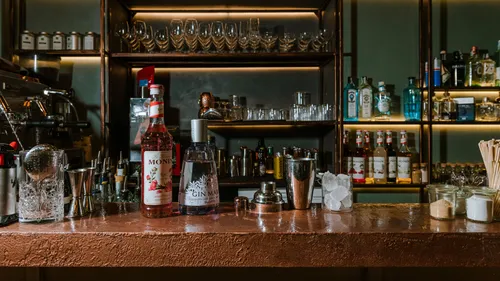 Bar counter with bottles and glasses.