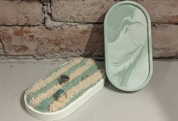 Dekorative Tabletts mit Ringen auf Regal.
