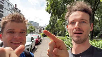Zwei Personen zeigen, stehen auf einer Stadtstraße.