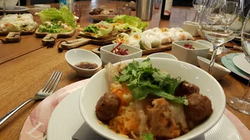 Vietnamesisches Essen mit Schalen, Rollen und Gewürzen.
