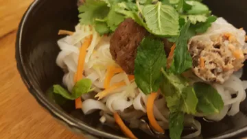 Schüssel Nudeln mit Gemüse und Kräutern.