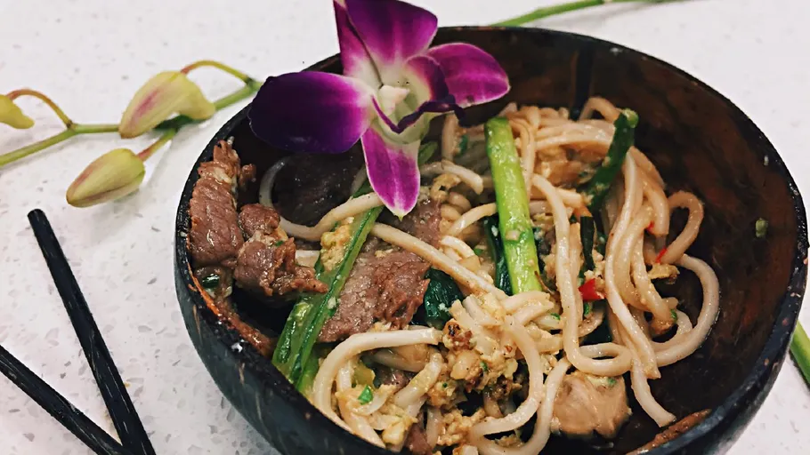 Nudeln mit Fleisch und Blumen in Schüssel.