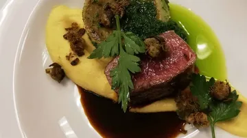 Steak mit Soße auf einem weißen Teller.