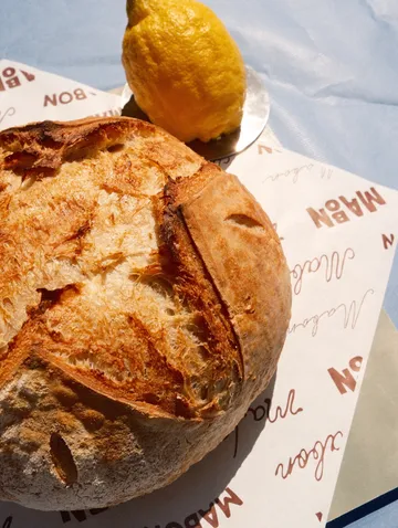 Rundes Brot und Zitrone auf Papier.