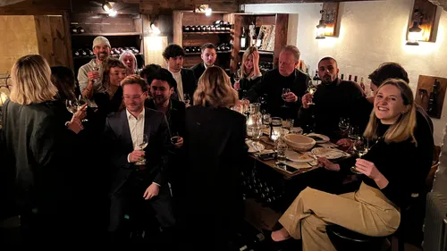 People toasting wine in cozy restaurant.