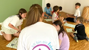 Children sitting on floor doing crafts.