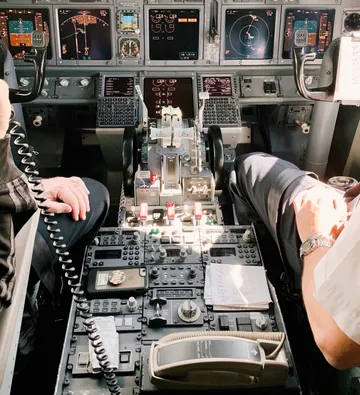 Piloten im Cockpit eines Flugzeugs bedienen Bedienelemente.