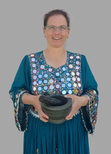 Woman holds mortar and pestle, grey background.