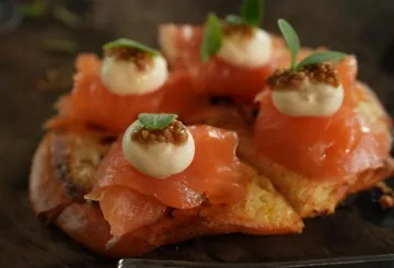 Gourmet-Vorspeise mit Lachs, Creme, Kräutern auf Brot.
