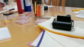 Kunstwerkzeuge und Materialien auf Holztisch.