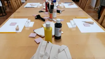 Kunstbedarf auf Holztisch angeordnet.
