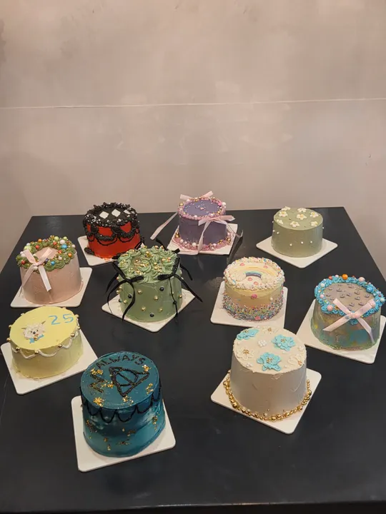 Dekorative Kuchen auf schwarzem Tisch ausgestellt.