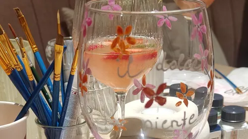 Bemaltes Glas mit Pinseln und Farben nah.