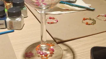 Beaded wine glass on arts and crafts table.