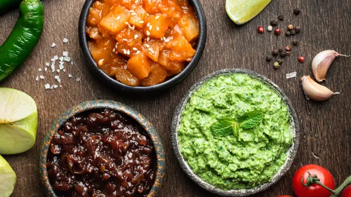 Three dips in bowls on wooden table.