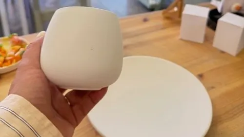 Hand hält Tasse nahe Holztisch.