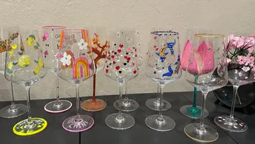 Decorated wine glasses on a dark table.
