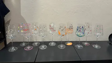 Decorated wine glasses on black table.