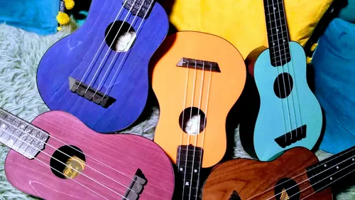 Colorful ukuleles placed on soft cushions.