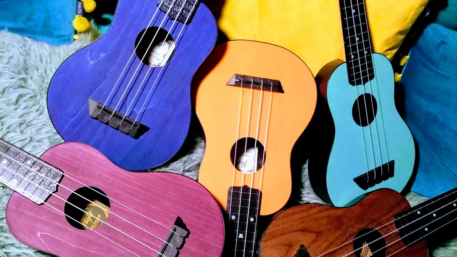 Colorful ukuleles placed on soft cushions.
