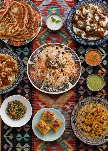 Assorted Middle Eastern dishes on patterned fabric.