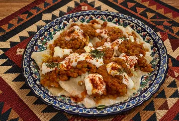 Plate of dumplings topped with spicy lentils.