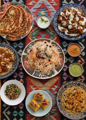 Assorted Middle Eastern dishes on colorful tablecloth.