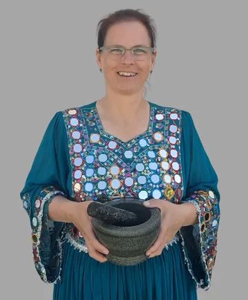 Woman holding mortar and pestle, gray background.