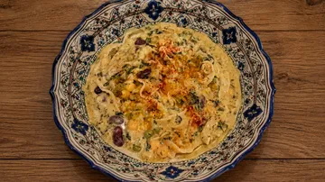 Decorative bowl with a mixed curry dish.