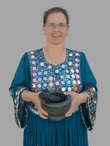 Woman holding mortar in decorative dress.