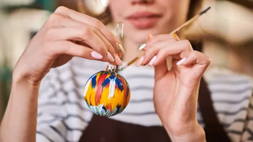 Person malt buntes Ornament drinnen.