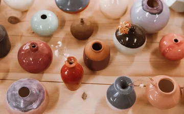 Colorful ceramic vases on wooden table.