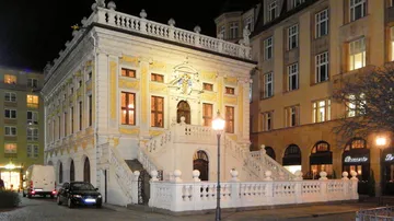 Prächtiges historisches Gebäude bei Nacht beleuchtet.