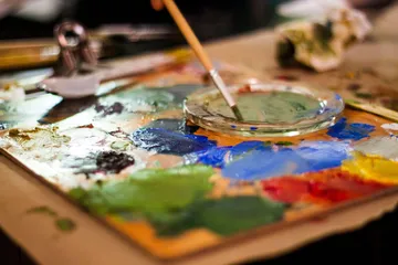 Palette mit bunten Farben und Pinsel.