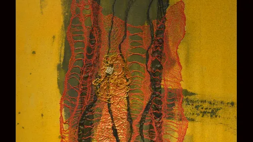 Abstract textile art with red threads.