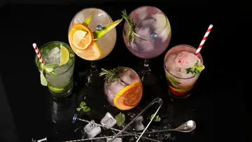 Bunte Cocktails auf schwarzem Hintergrund.
