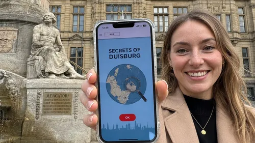 Frau hält Handy mit Duisburg-App.