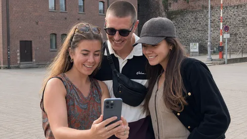 Drei Freunde machen draußen ein Selfie.