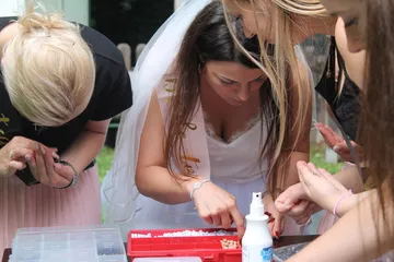 Frauen basteln Schmuck bei Veranstaltung im Freien.