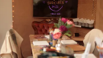 Table with crafts, screen, cozy room.