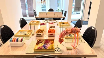 Craft table with colorful flowers and materials.