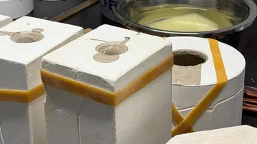 Two molds prepared on a workshop table.