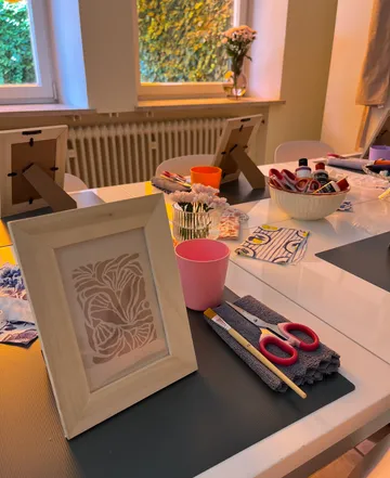 Framed artwork on crafting table setup.