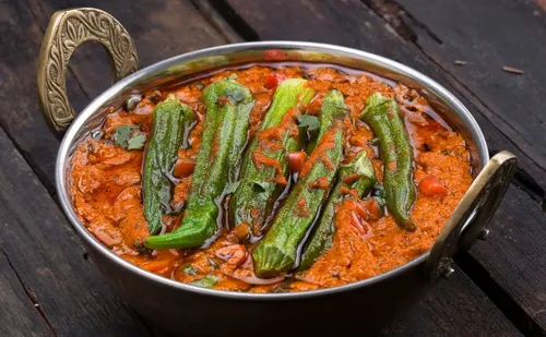 Curry mit Okra in verziertem Metallgefäß.