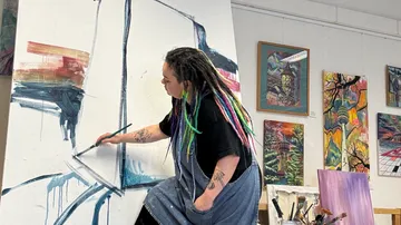 Künstler malt auf großer Leinwand im Atelier.