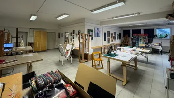 Art studio filled with easels and art supplies.
