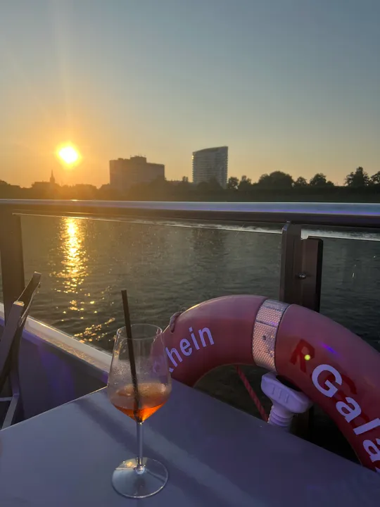 Drink on boat with sunset view.