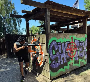 Mann mit Waffe versteckt sich im Paintball-Park.