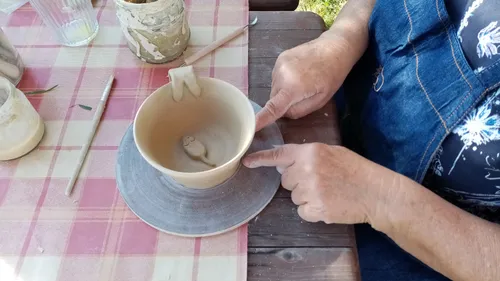 Töpfer formt Tonschale im Freien.