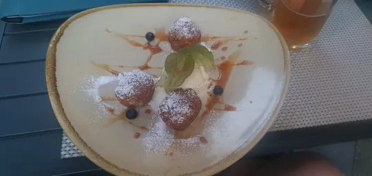 Dessertkugeln mit Puderzucker auf Teller.